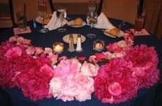 Bouquets of flowers placed around the edge of the bride and groom table