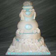 Picture of an elegant white cake with draping and a crystal tiarra.