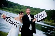 Bride and groom holding a big sign that says thank you