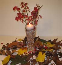 Autumn leaves for your reception centerpiece including a candle with flowers