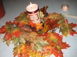 Candles surrounded by leaves as a wedding reception decoration